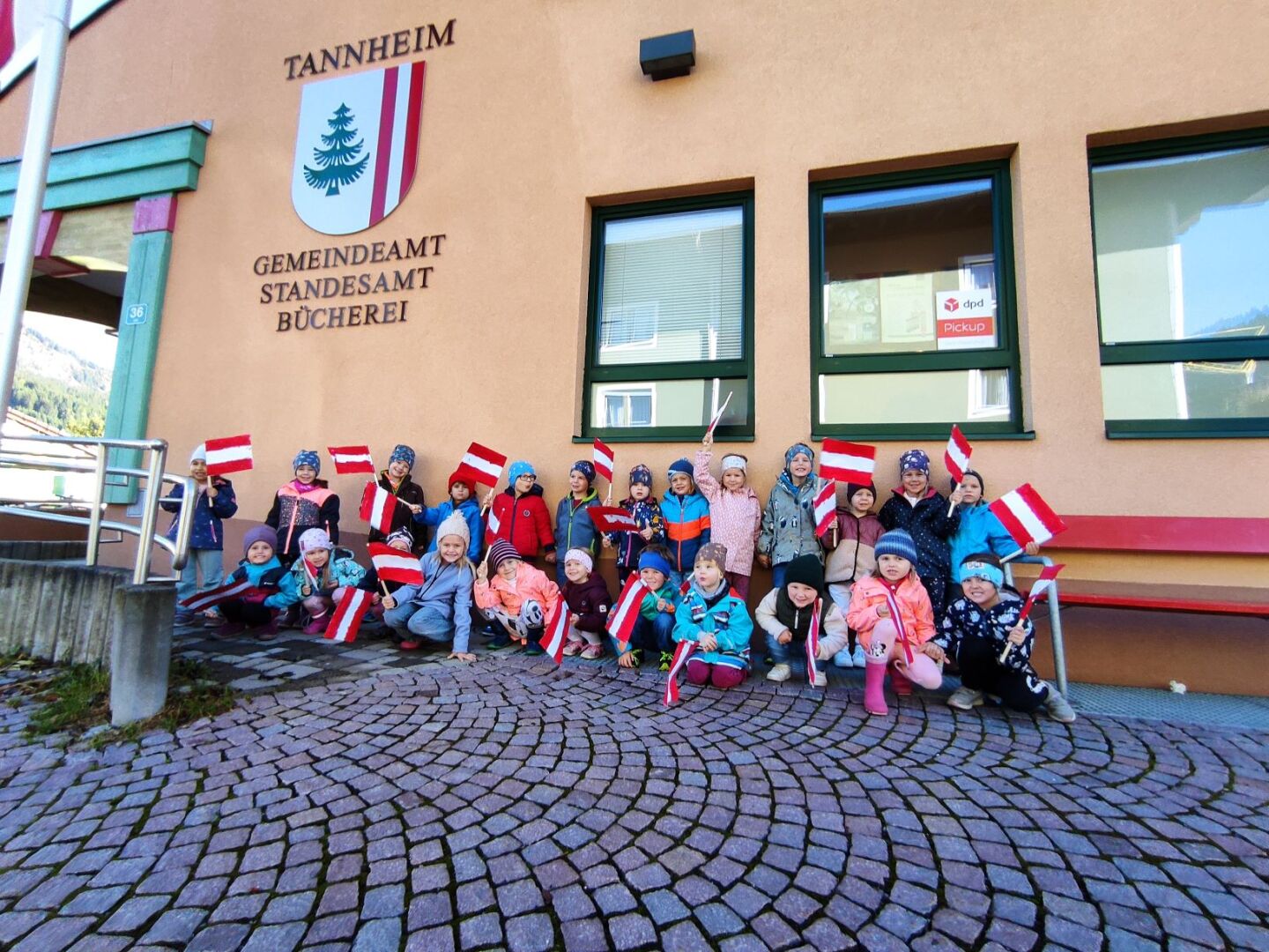 Kindergartenkinder, die vor dem Gemeindeamt für ein Foto posieren